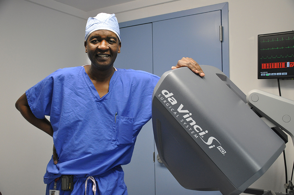 Dr Mushayandebvu standing next to da Vinci surgical machine