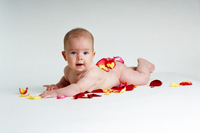 Photo of a baby sprawled on colorful petals